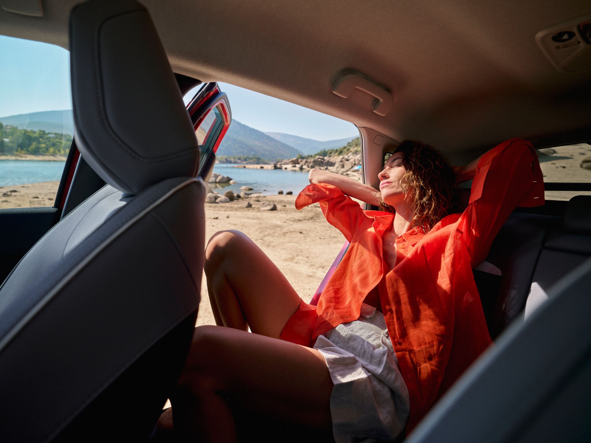 Vista interior trasera del ë-C4 destacando confort espacioso, relajación, serenidad y diseño para un momento exterior tranquilo y premium.