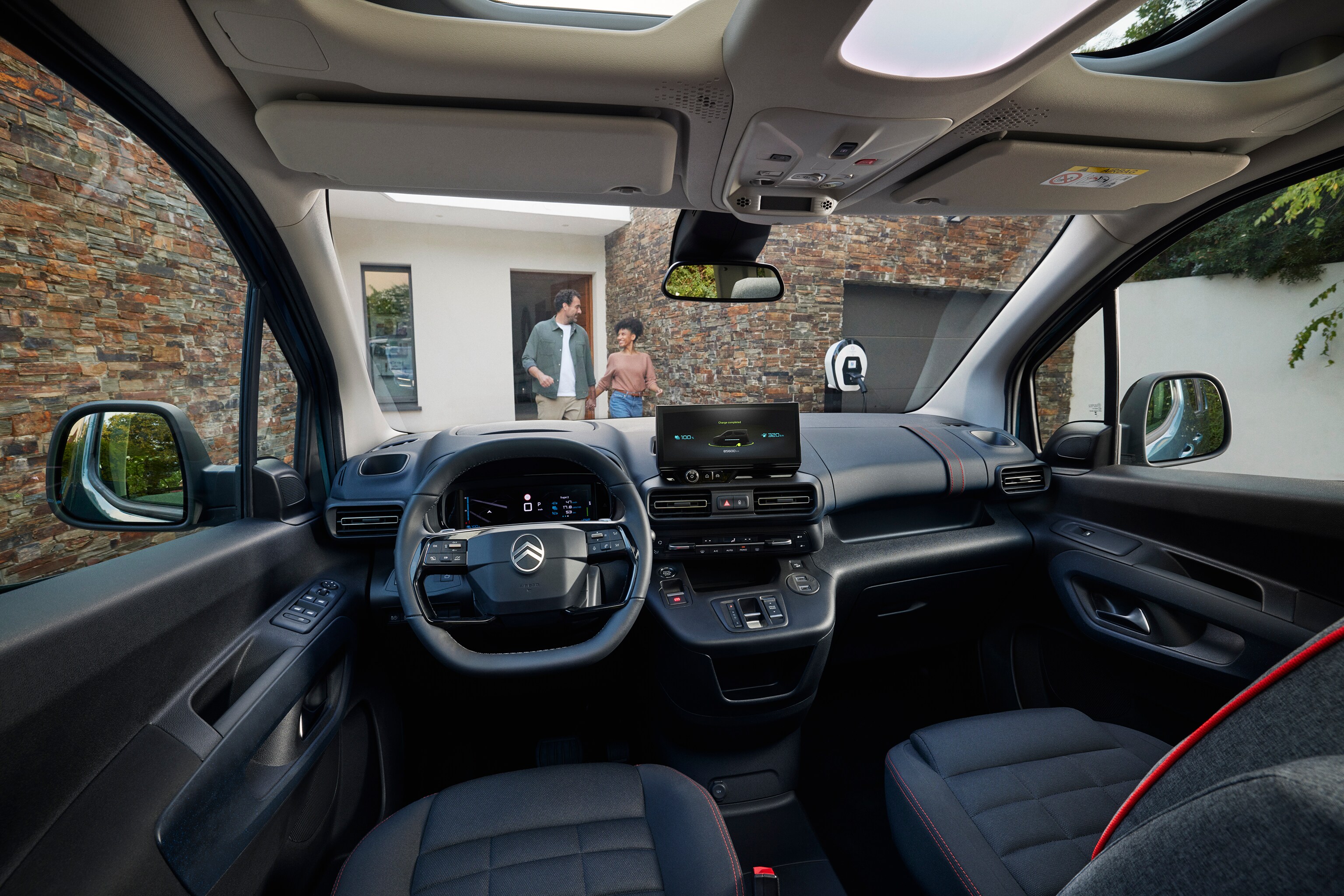 Vista interior frontal del ë-Berlingo mostrando techo panorámico, confort, espacio, conectividad y experiencia de conducción diaria mejorada
